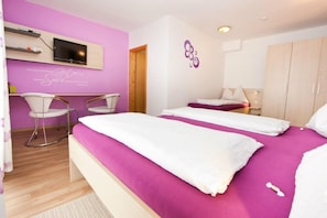 A hotel room with two beds, a TV, a desk, and a chair. - Gasthof Spengerwirt (Hirschegg)