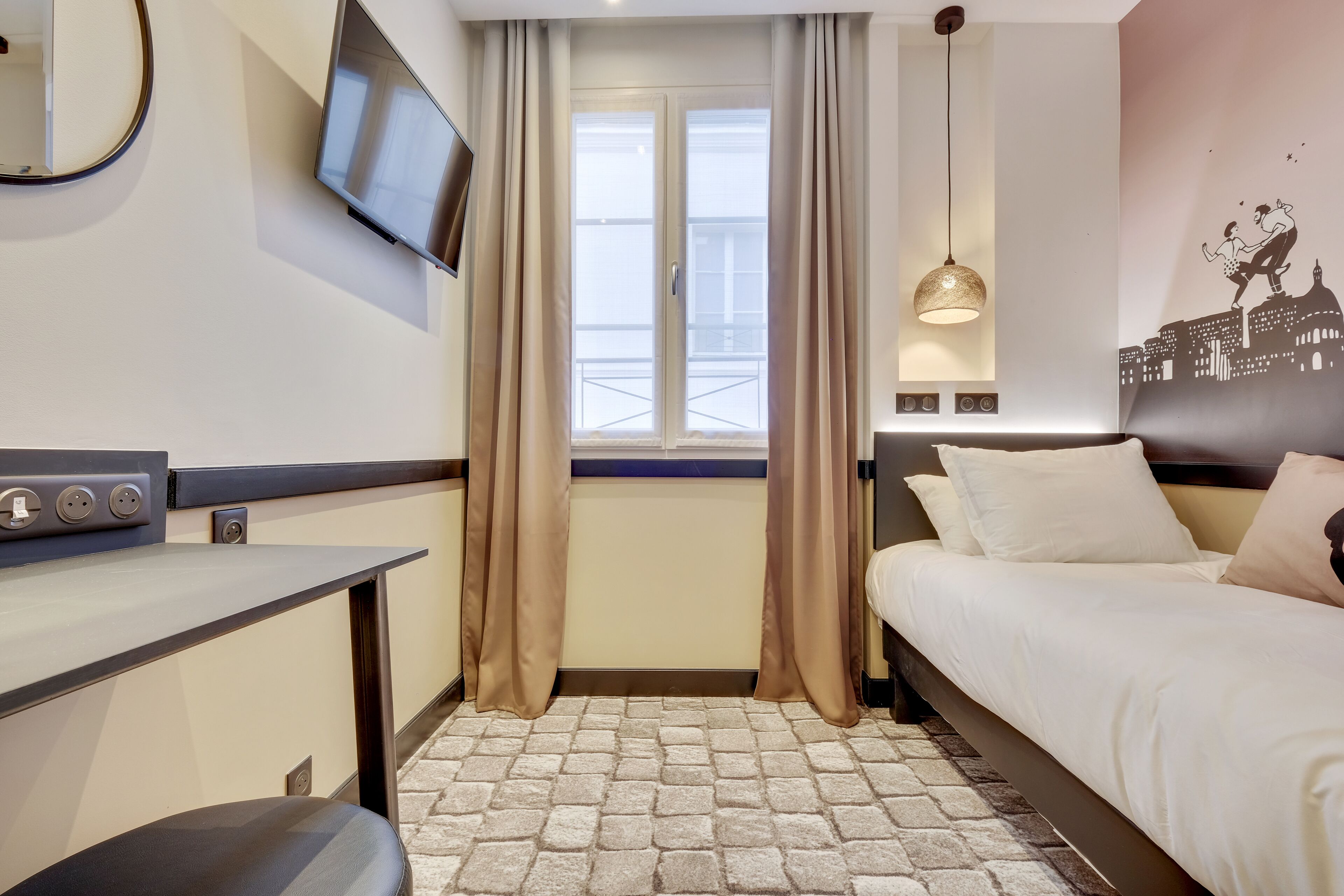 Habitación de hotel con una cama, un escritorio, un televisor, una ventana con cortinas y una obra de arte urbana en la pared.