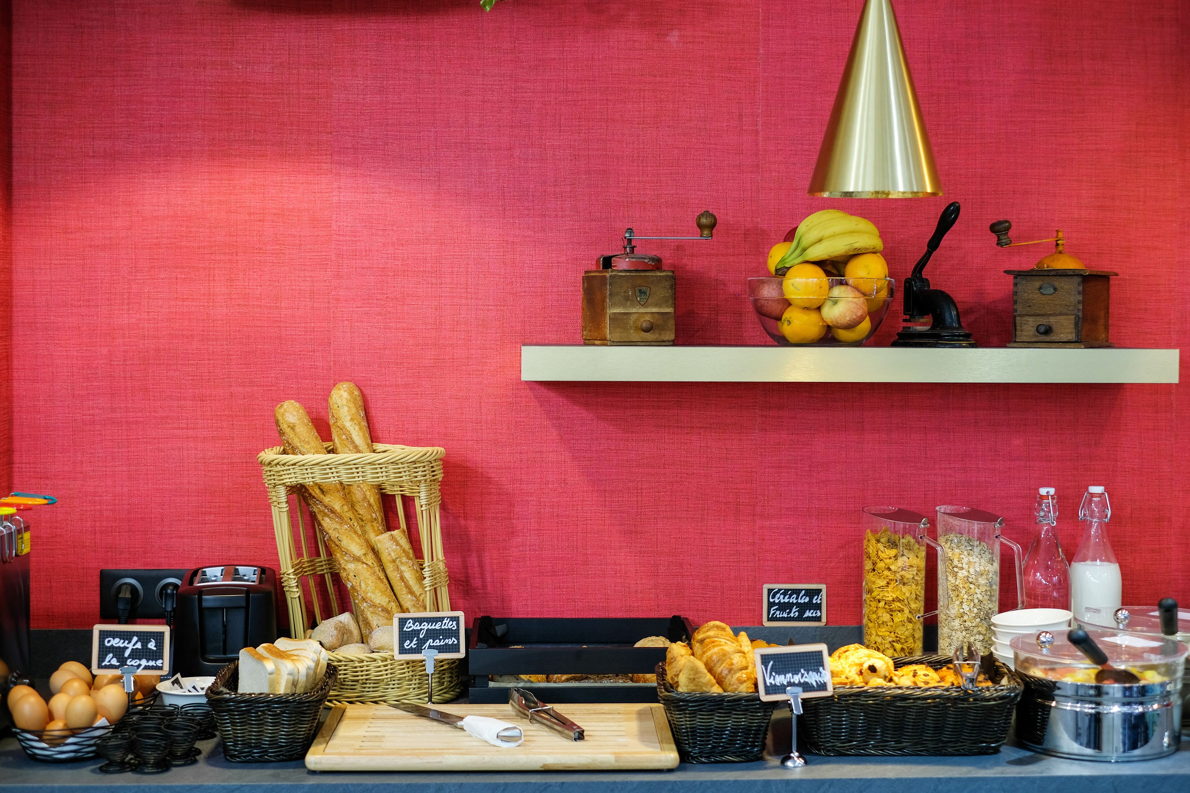 Un bufé de desayuno con panes, bollería, frutas y bebidas.