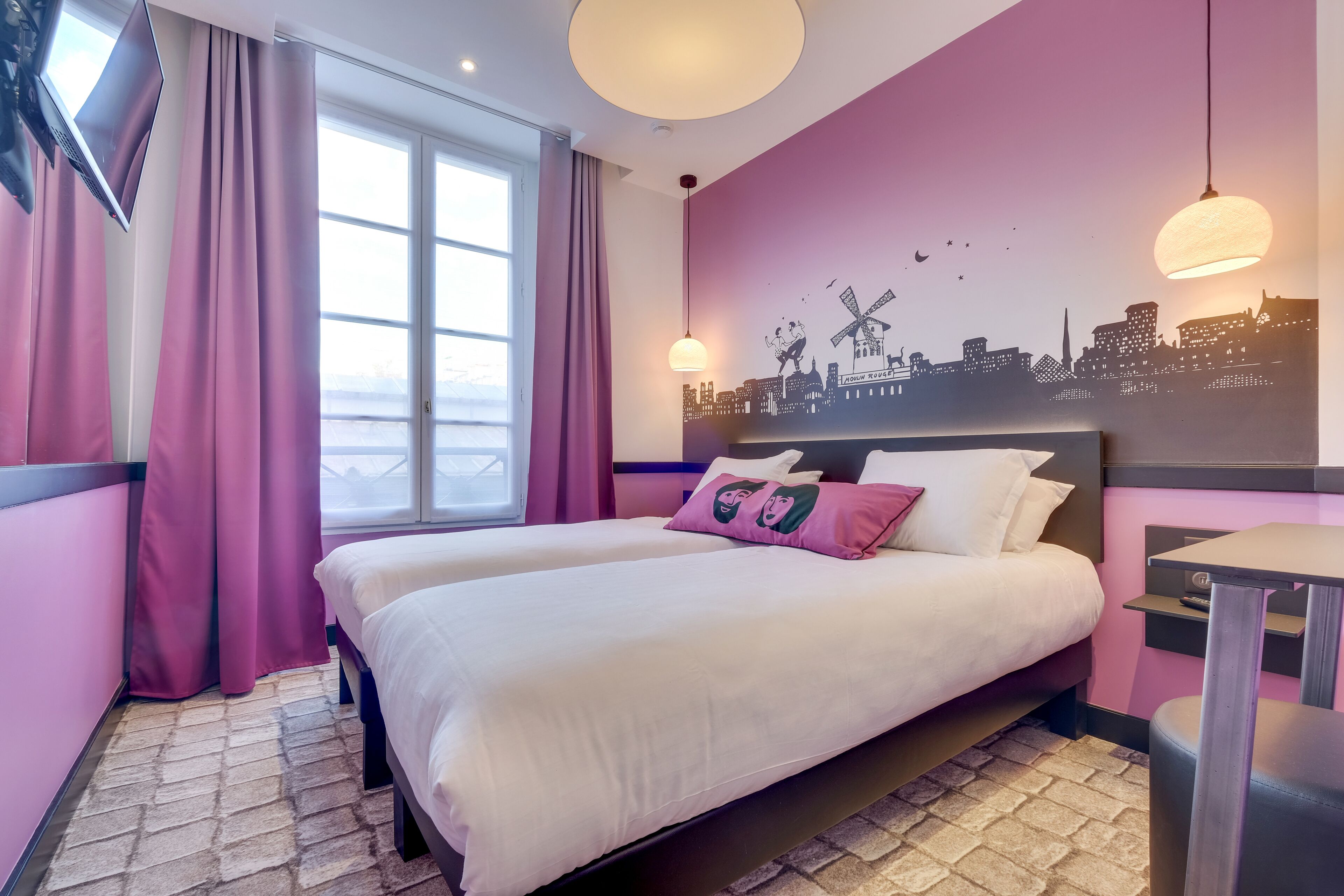Habitación de hotel con una cama grande, un mural de paisaje urbano y vistas de la ciudad a través de la ventana.