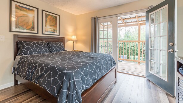 A bedroom with a bed, a ceiling fan, and a view of the outdoors through a sliding glass door. - Central Atlanta 8BR and 3600 sqft (Atlanta)