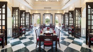 A dining area with a checkered floor, multiple tables, and chairs.