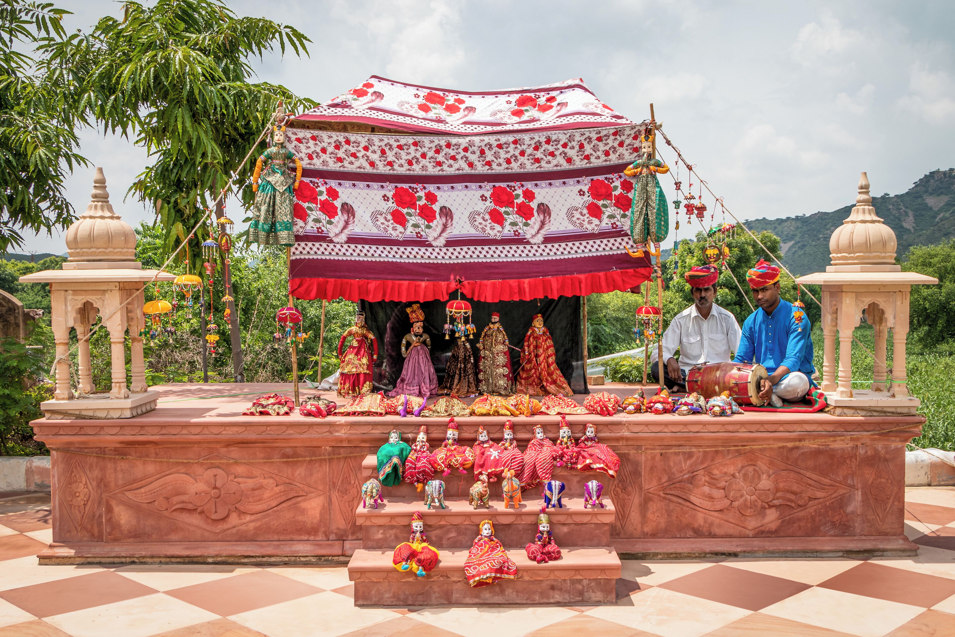 A temple with a tiered platform, statues, and a canopy.