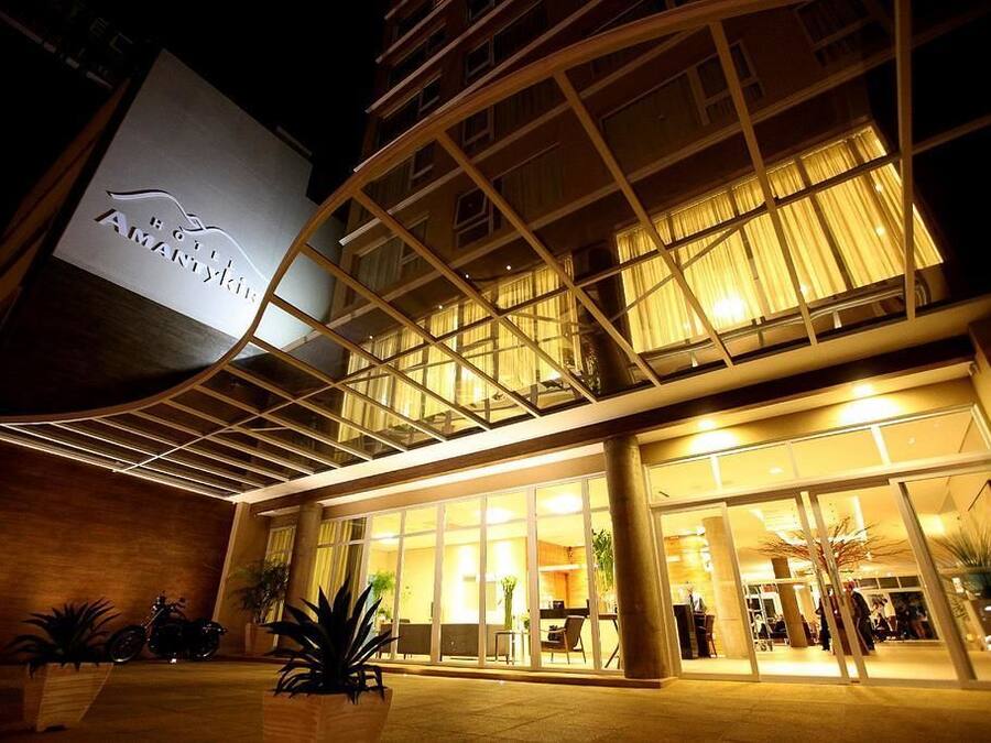 Ein Hotel mit modernem Design, das eine große Glasfassade und ein Schild mit dem Schriftzug 'Hotel Amanitikin' zeigt.