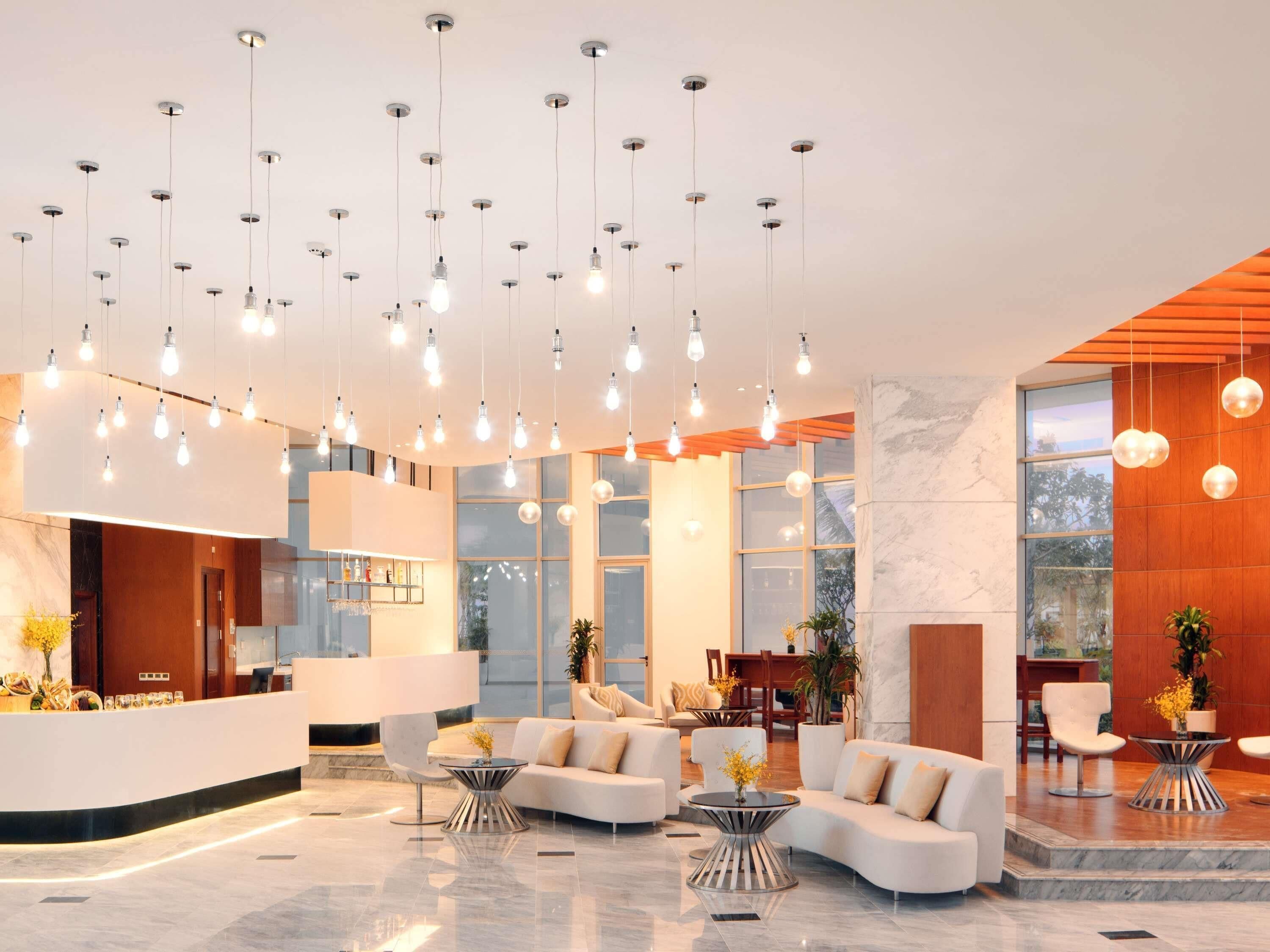 Un hall d’entrée moderne avec un comptoir d’accueil, un espace salon et de grandes fenêtres.