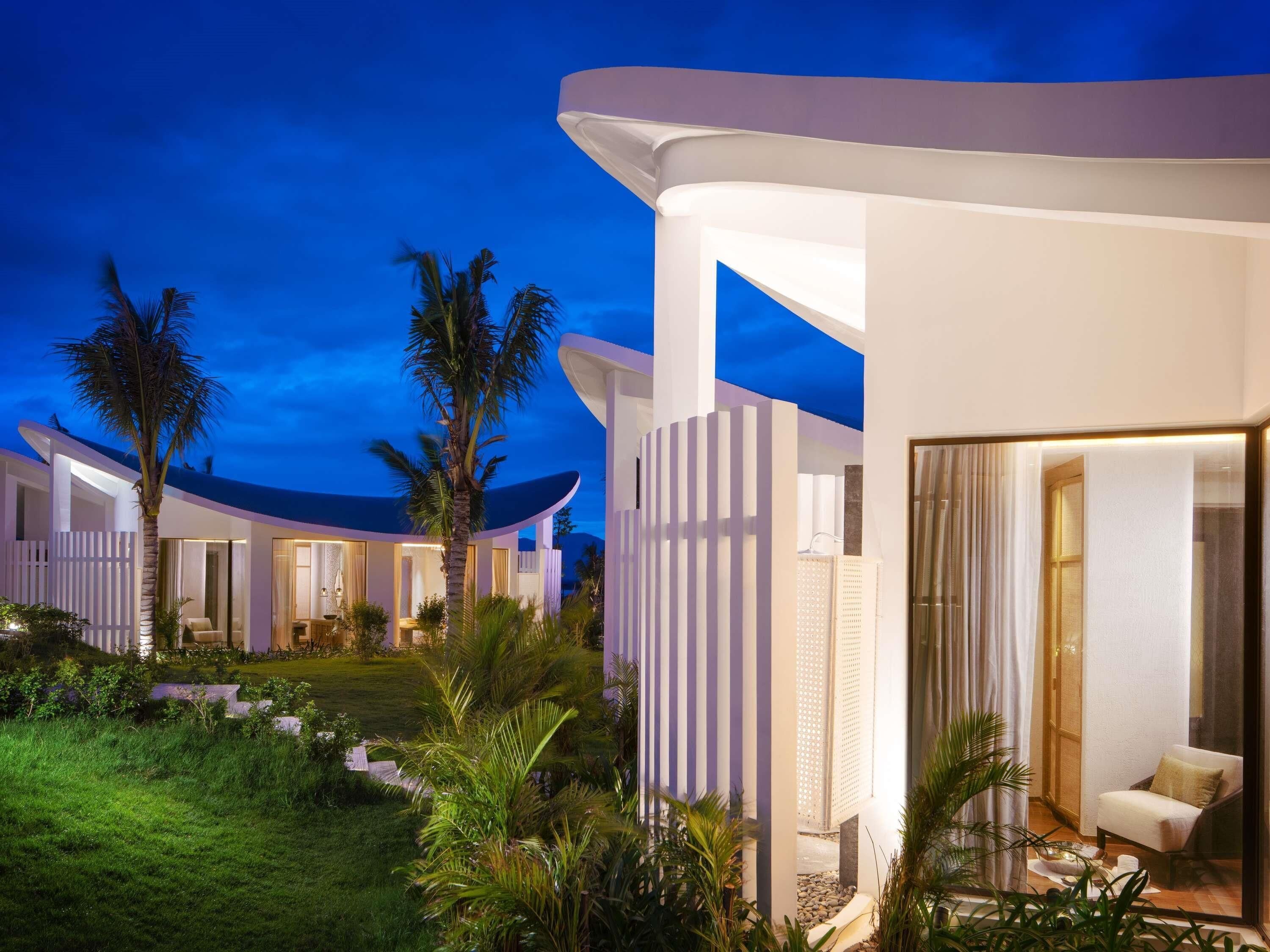 A modern resort with multiple guest rooms, a well-maintained garden, and a clear view of the night sky.