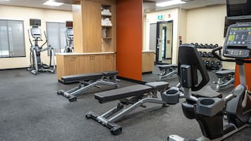 Un gimnàs amb cintes de córrer, màquines el·líptiques i una pica de musculació.