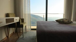 A bedroom with a bed, a desk, and a chair. - Hotel Rural da Freita (Arouca)