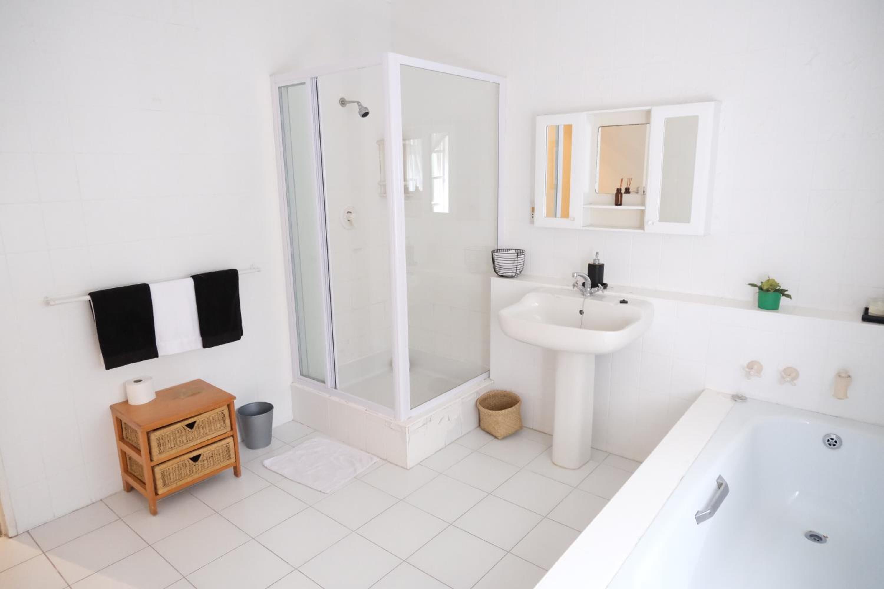A modern bathroom with a glass-enclosed shower, a sink, and a bathtub.