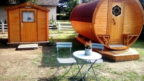 A wooden cabin with a small porch and a large barrel-shaped structure. - Les Tonneaux de l'Eure Logement Insolite (Neuilly)