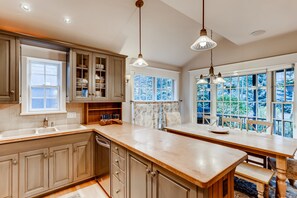 Enjoy cooking with a view from this kitchen featuring a large island, ample storage, and expansive windows.