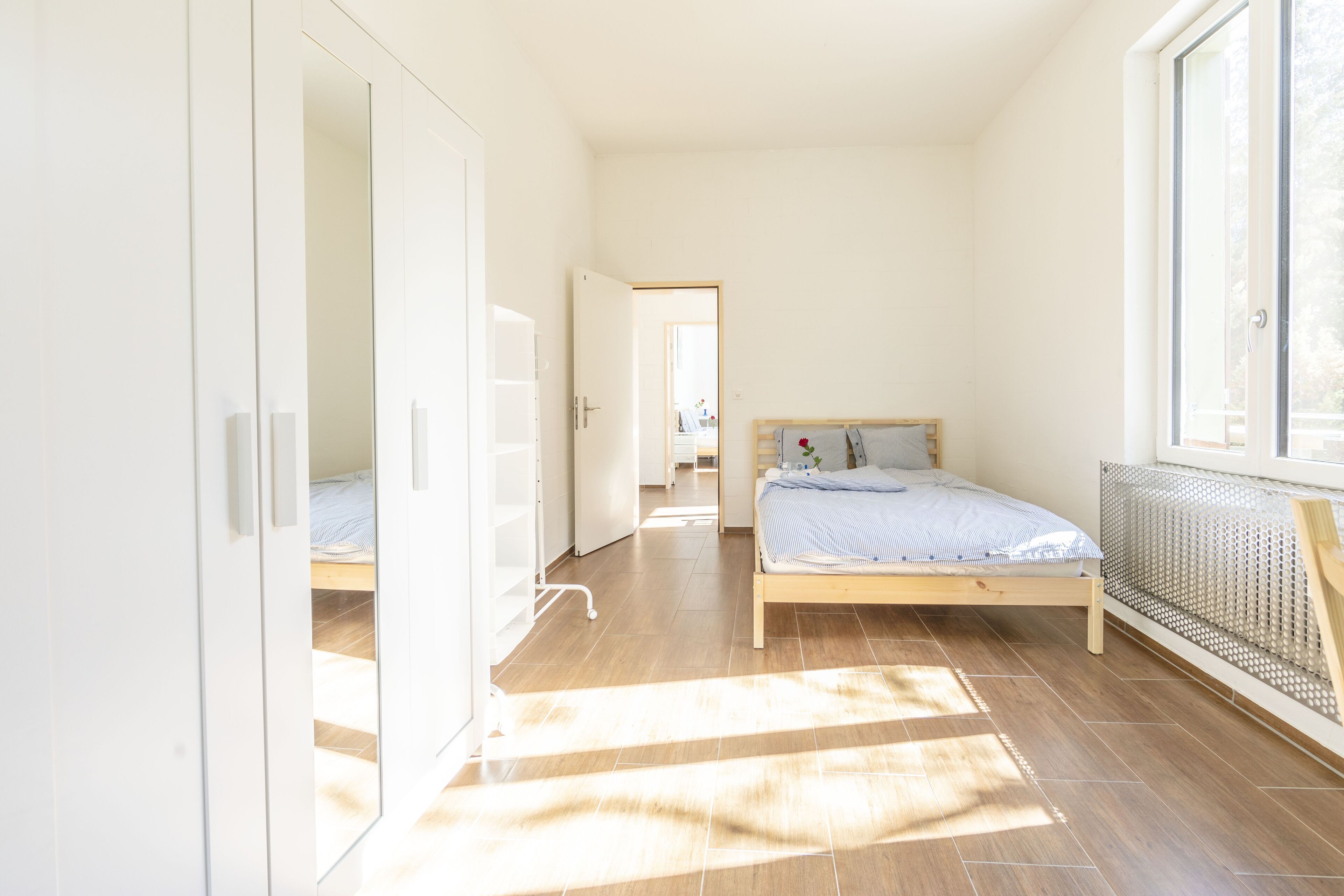 Une chambre à coucher avec un lit, un radiateur et une fenêtre.