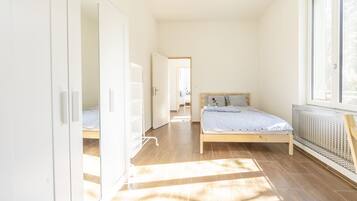 A bedroom with a bed, a radiator, and a window.