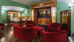 A lobby with red chairs, a bar area, and a large screen.