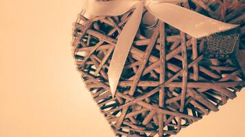 A heart-shaped wicker decoration with a ribbon and a small ornament.