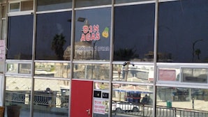 A storefront with large windows, a sign reading "Habanim 1 D'lan" and "Agas complex" with a contact number. - Agas Holiday Apartments Gefen Boutique (Tiberias)
