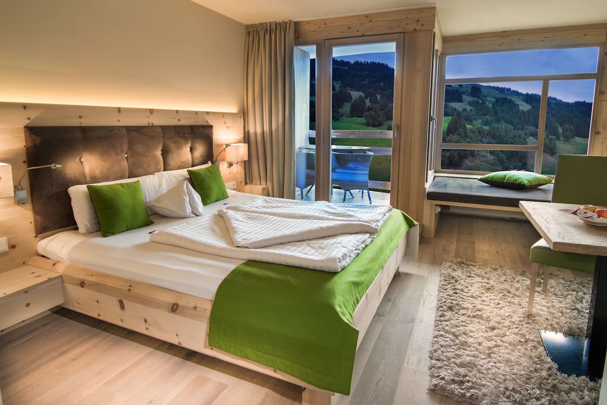 Une chambre à coucher avec un lit, une table de chevet, une table et une vue sur un balcon.