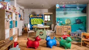 Explore a vibrant underwater world in this imaginative playroom, featuring a large mural and engaging toys and educational materials.