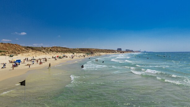 A beach with clear waters, sandy shore, and people enjoying the beach. - Lagoon Amazing water front 3 (Herzliya)