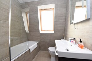 Un baño moderno con bañera, inodoro y lavabo.