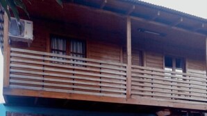 Un edificio de madera con un balcón y una ventana.