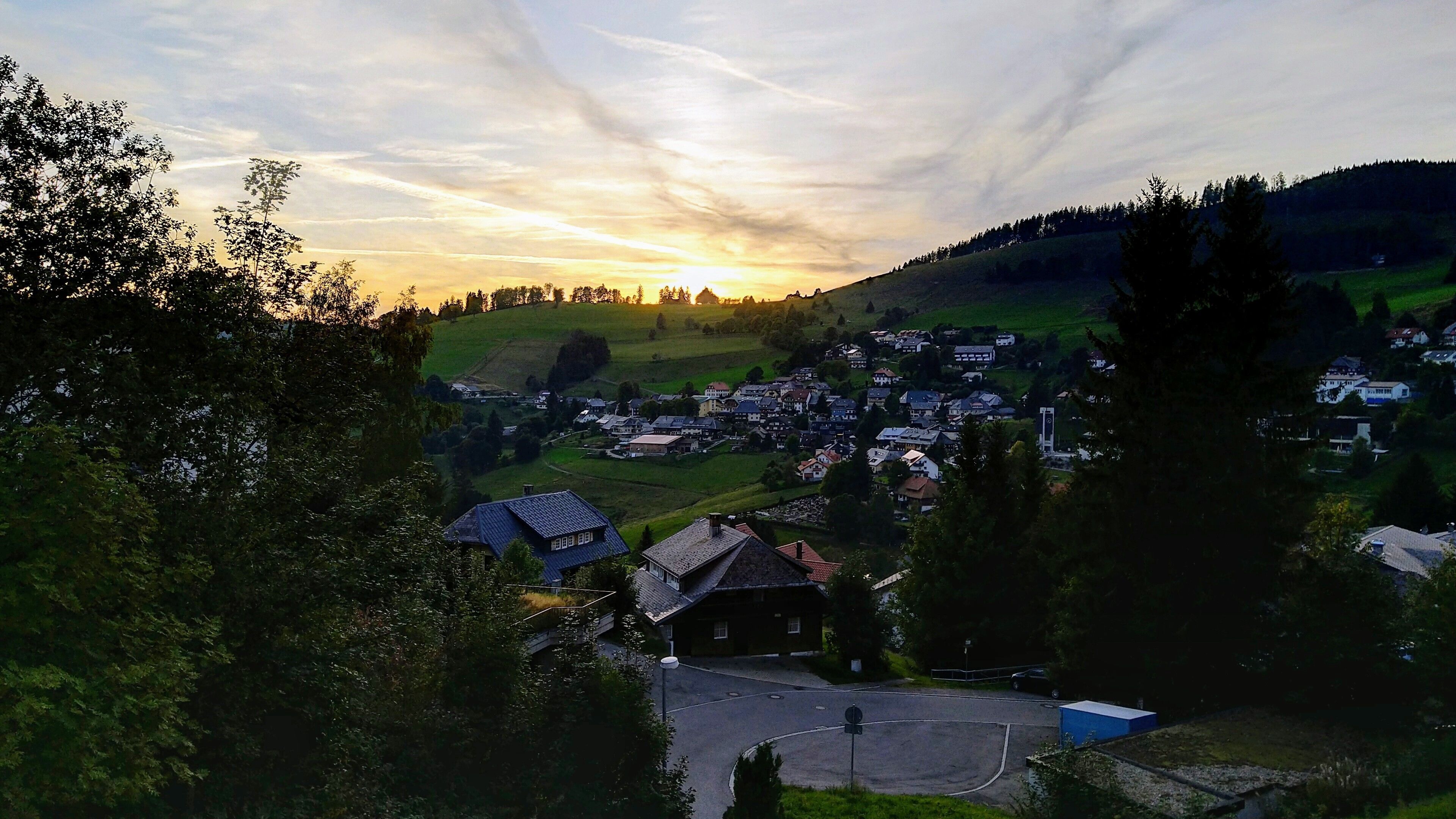 Ein ländliches Dorf mit Häusern, einer Kirche und einer Straße.