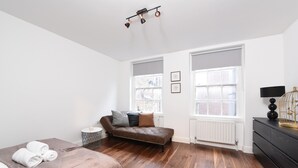 Ein modernes Schlafzimmer mit einem großen Bett, einer Couch und einer Kommode.