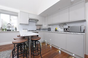 City appartement | Privékeuken | Een koelkast met diepvriezer, een microgolfoven, een oven, een kookplaat