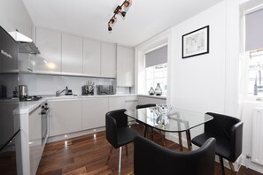 Standaard appartement | Privékeuken | Een koelkast met diepvriezer, een microgolfoven, een oven, een kookplaat