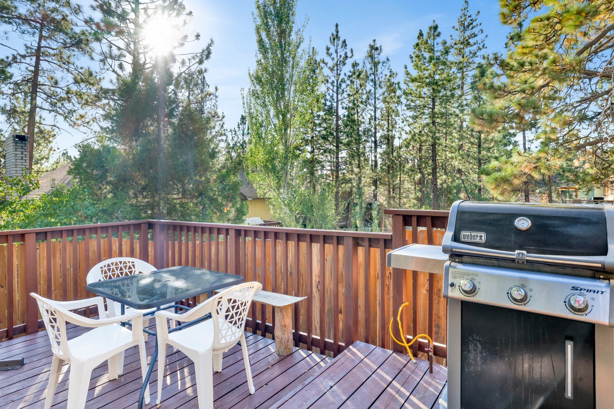 Une terrasse extérieure avec un barbecue, une table et des chaises.