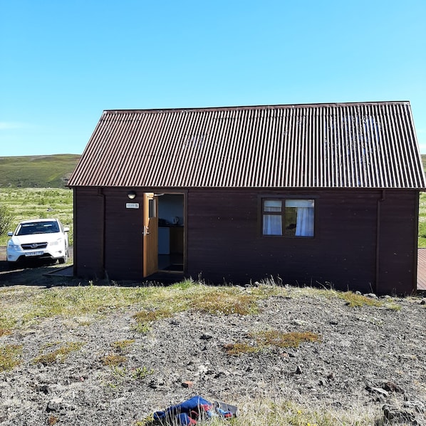 A small, single-story building with a corrugated metal roof, a visible door, and a window. - Guesthouse Hagi 1 (Husavik)
