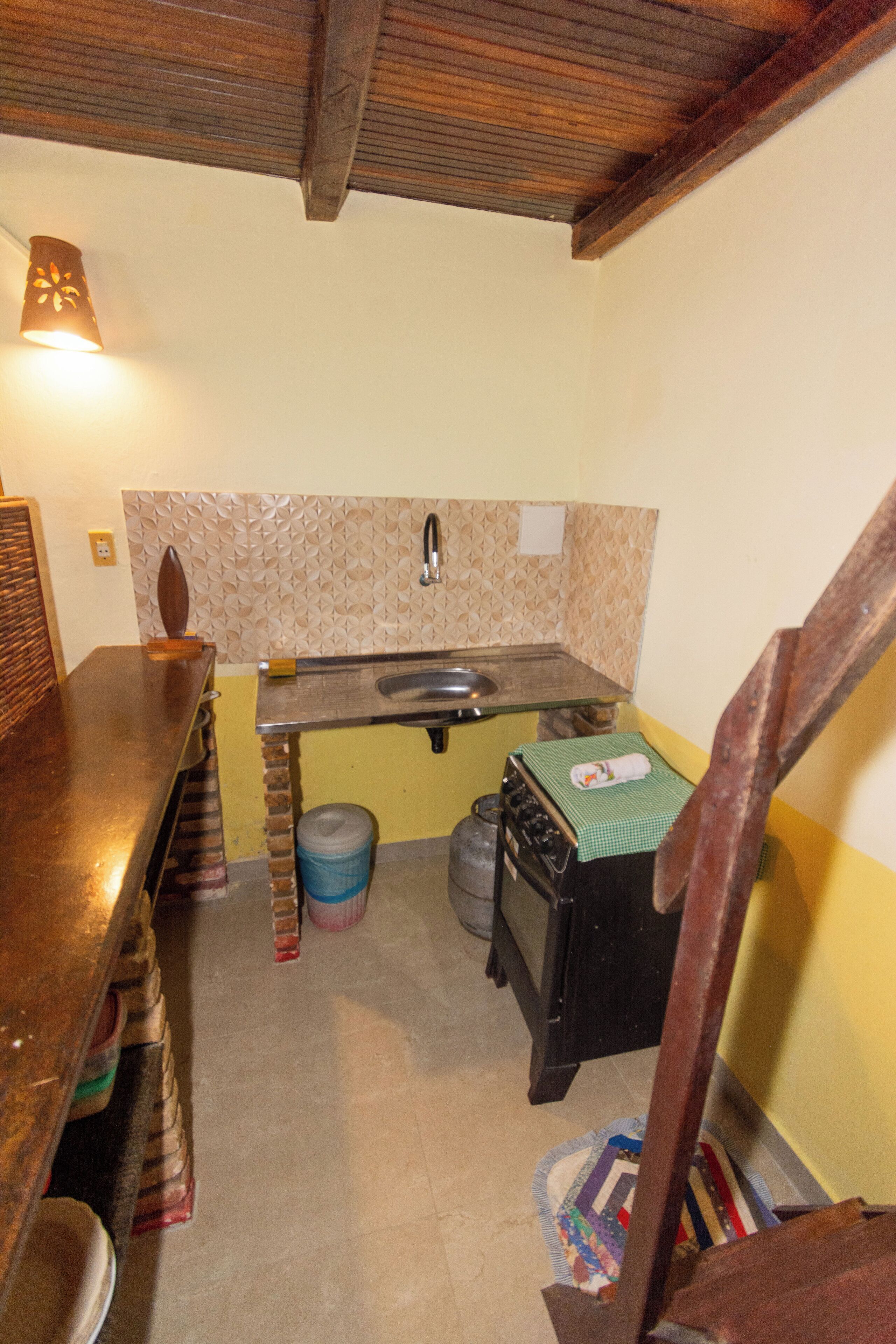 Cocina compacta con lavamanos, encimera de madera y salpicadero estampado.