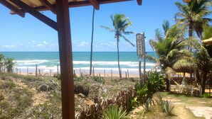 A beach view with a wooden structure, palm trees, and a sign indicating 'CASA CIMALE'. - Casa ImBale (Mata de São João)