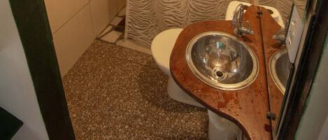 A small bathroom with a wooden vanity, two sinks, a toilet, and a zebra-patterned shower curtain.