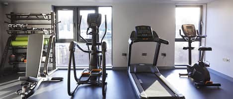 A gym with treadmills, elliptical machines, and a weight rack.