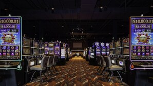 A casino with multiple slot machines and chairs arranged in rows.