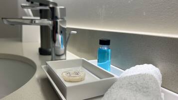 A bathroom sink with a soap dish, a blue bottle, and a white towel.