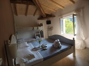 A bedroom with a bed, bedside table, lamp, and a window with curtains. - B&B Big Sur (Gardone Riviera)