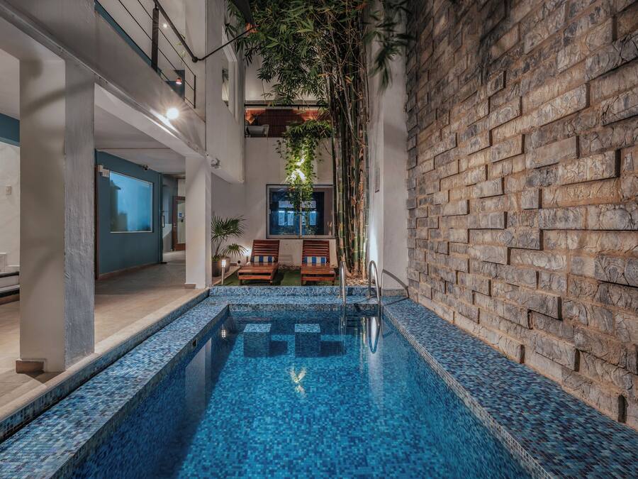 Una piscina al aire libre, sillones reclinables de piscina