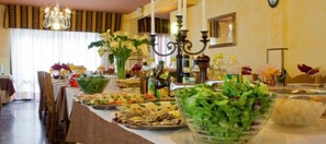 A buffet table with various dishes and a chandelier. - Hotel Villa Bruna (Caorle)