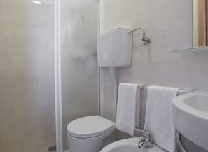 Un baño moderno con inodoro, bidé y lavamanos.