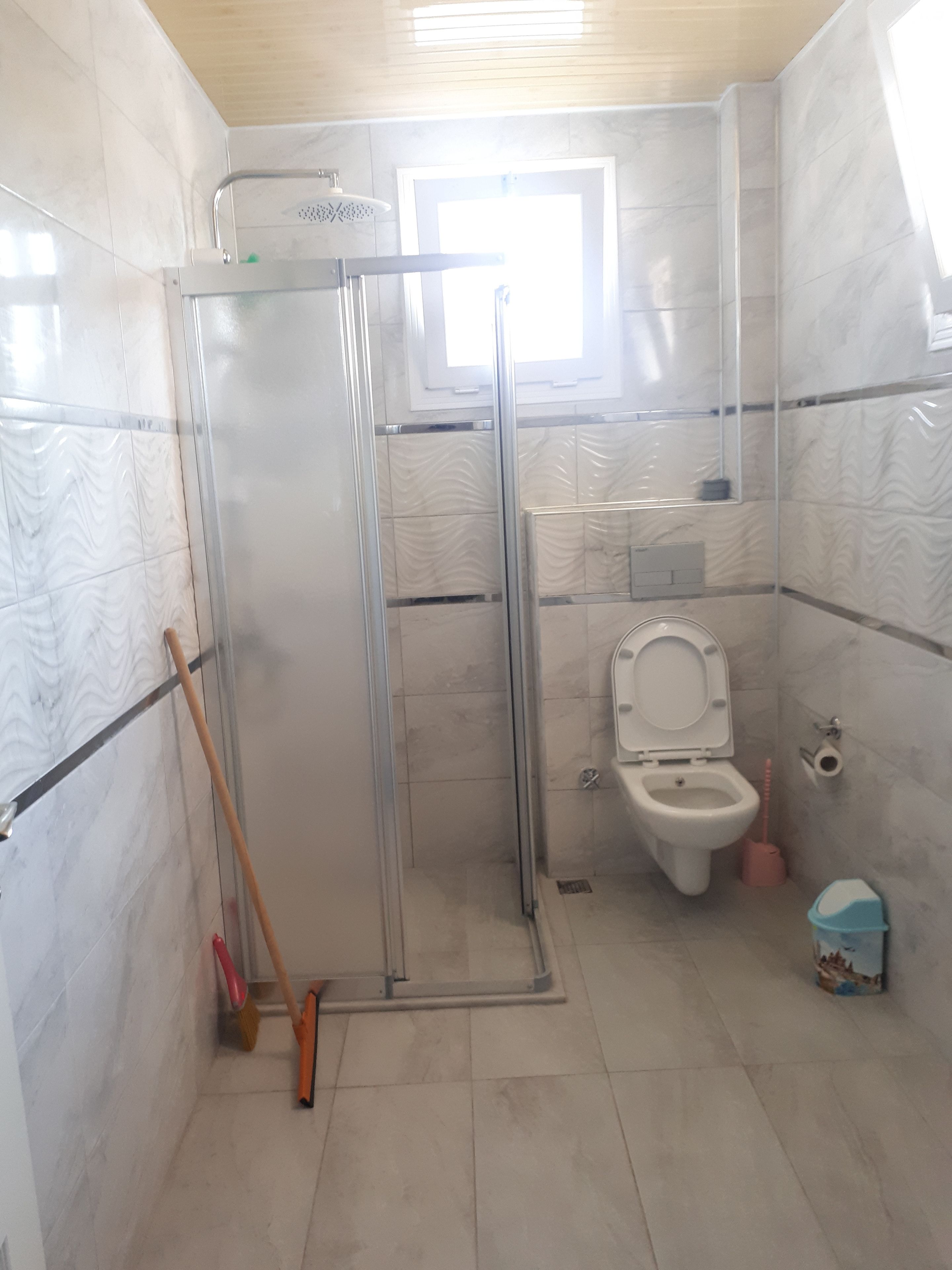 Un baño con cabina de ducha de vidrio, inodoro y bidé.
