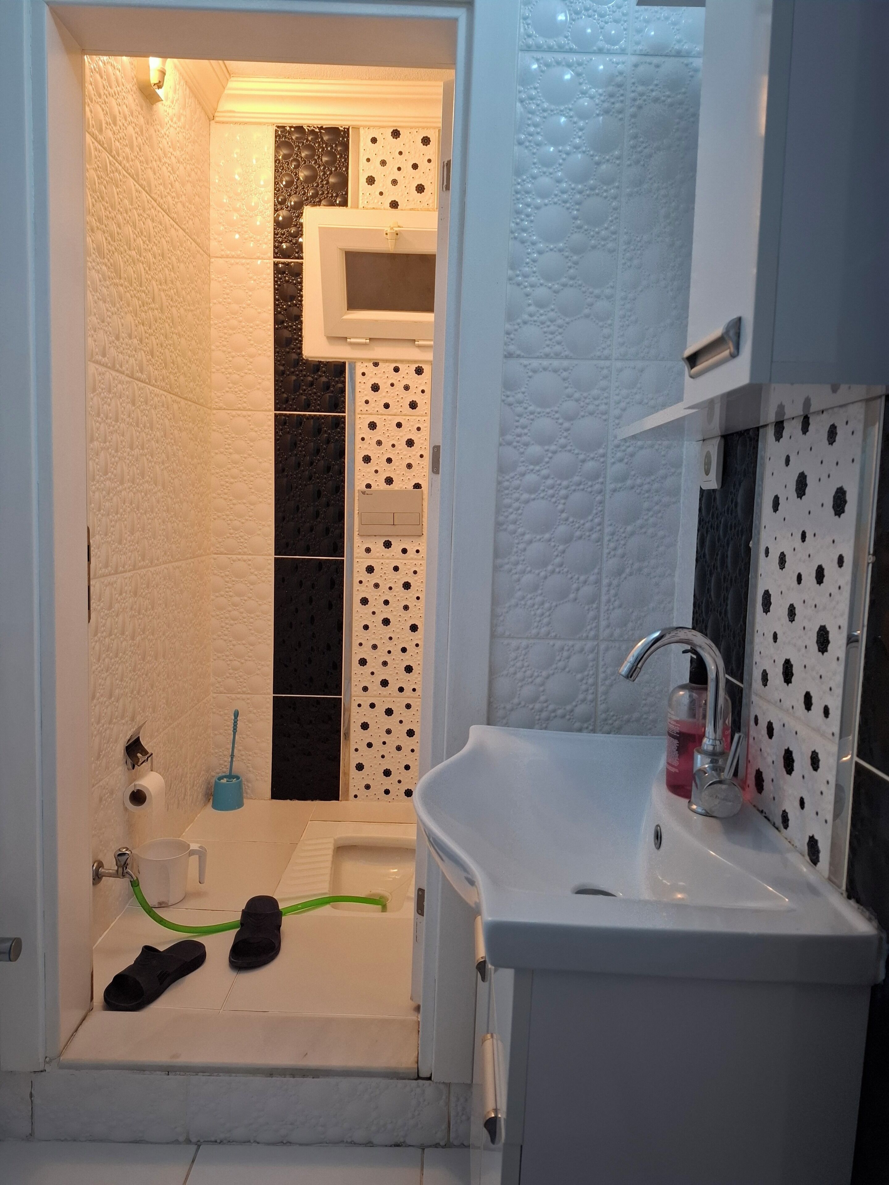 A bathroom with a shower, toilet, and sink.