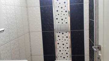 A small bathroom with a toilet, a sink, and a mirror.