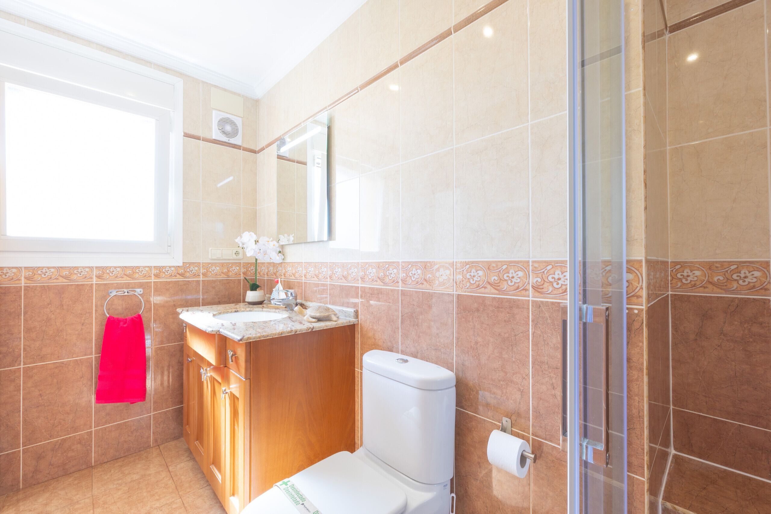 Une salle de bain avec des toilettes, un lavabo et une douche.