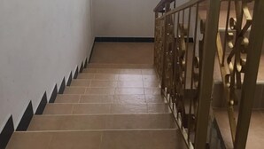 Una escalera con barandilla estampada y un ventanal con diseño geométrico.