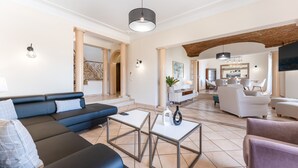 Un vaste espace de vie comprenant un canapé d’angle, une table basse et un coin repas avec des chaises et une table.