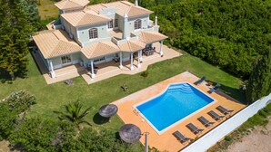 Une grande maison avec de nombreuses pièces, une piscine et un jardin.