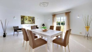 A dining area with a white table, six brown chairs, a decorative bowl, and a painting on the wall. - Villa Licinia - Three Bedroom Villa, Sleeps 6 (Guia)