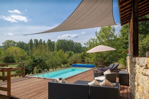 A wooden deck with a pool, lounge chairs, and a shade sail. - The Miller’s Cottage, cosy retreat, sleep 5, private pool, free Wifi (Nouvelle-Aquitaine)